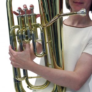 holding a large brass instrument
