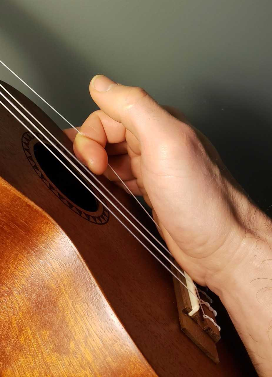 Pivot gently from your palm and keep it planted on the bridge to avoid unnecessary tension to the instrument body as shown